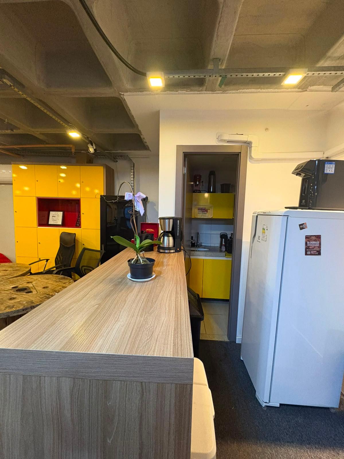 Copa com café, geladeira, mesas de convivência e armários amarelos KaizenHUB